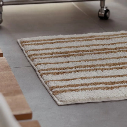 Close-up texture shot showing the fluffy pile of the caramel striped rug - RoomDen