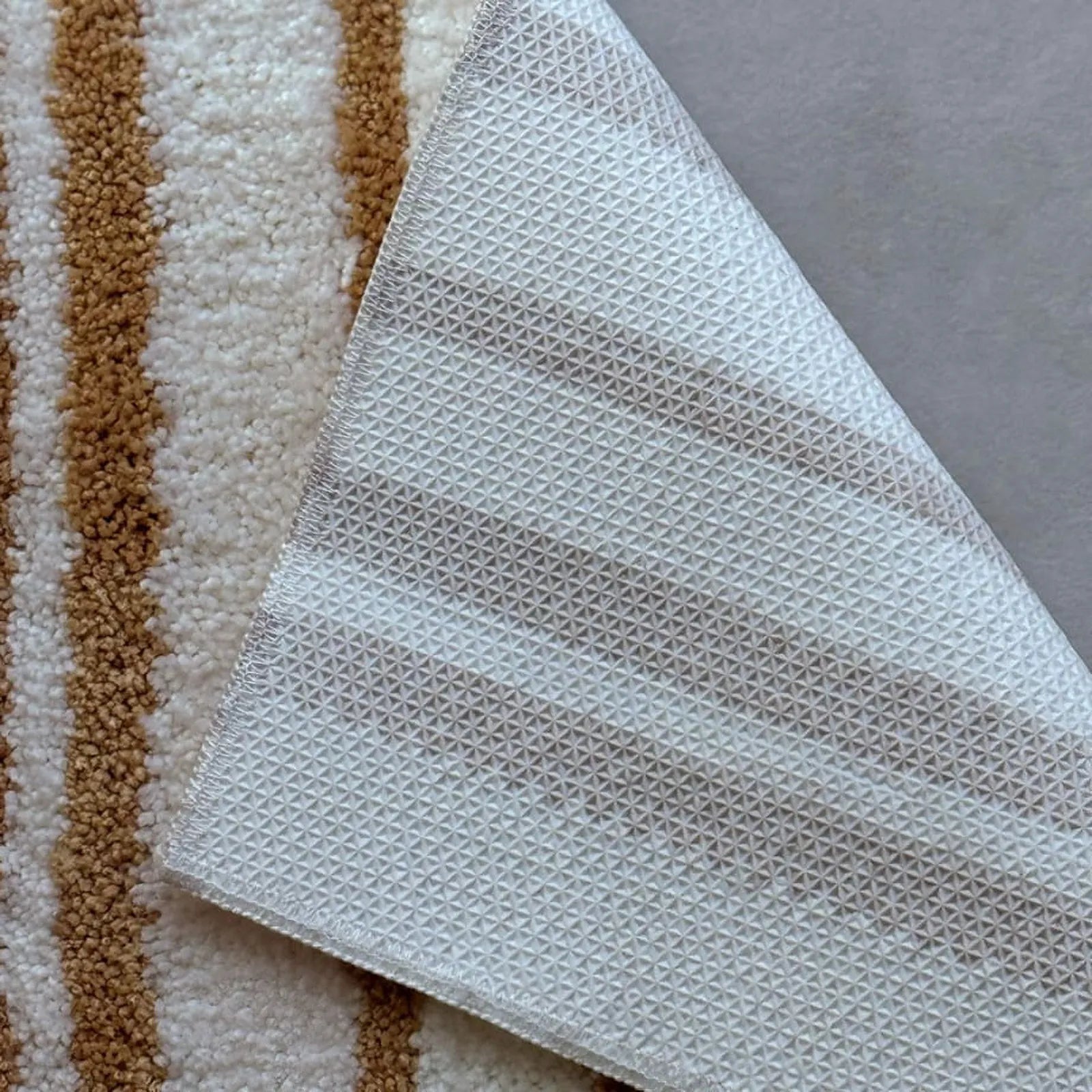Detail shot of the white geometric non-slip TPR backing folded over - RoomDen