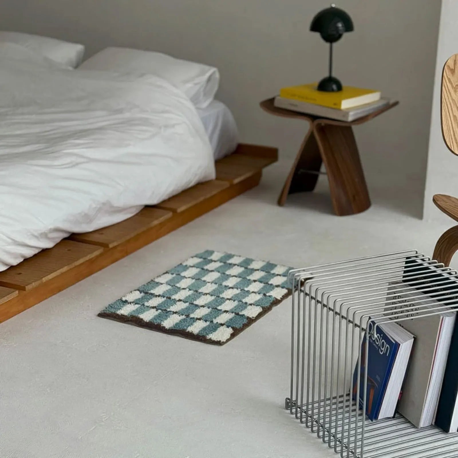 Bedroom interior featuring Wavy Checkerboard Plush Accent Rug on the floor between a metal side table and wooden furniture - RoomDen