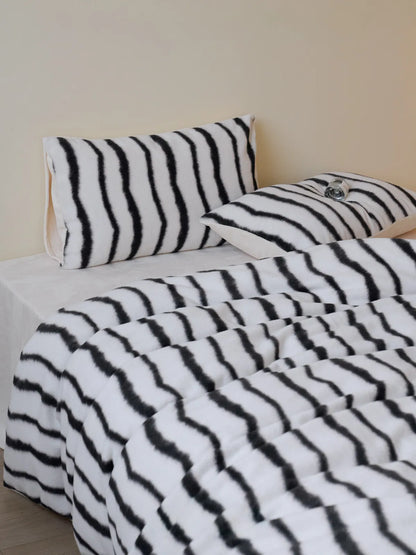 RoomDen black wavy striped flannel fleece bedding set styling with pillow detail.