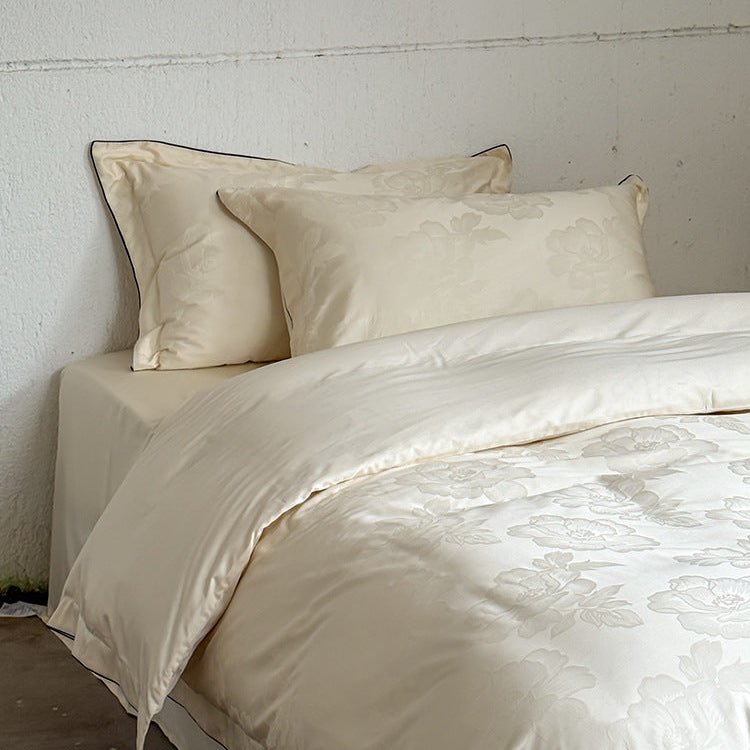 Ondine Floral Cotton Blend Bedding Set – matching ivory pillows above the folded floral bedding - Roomden
