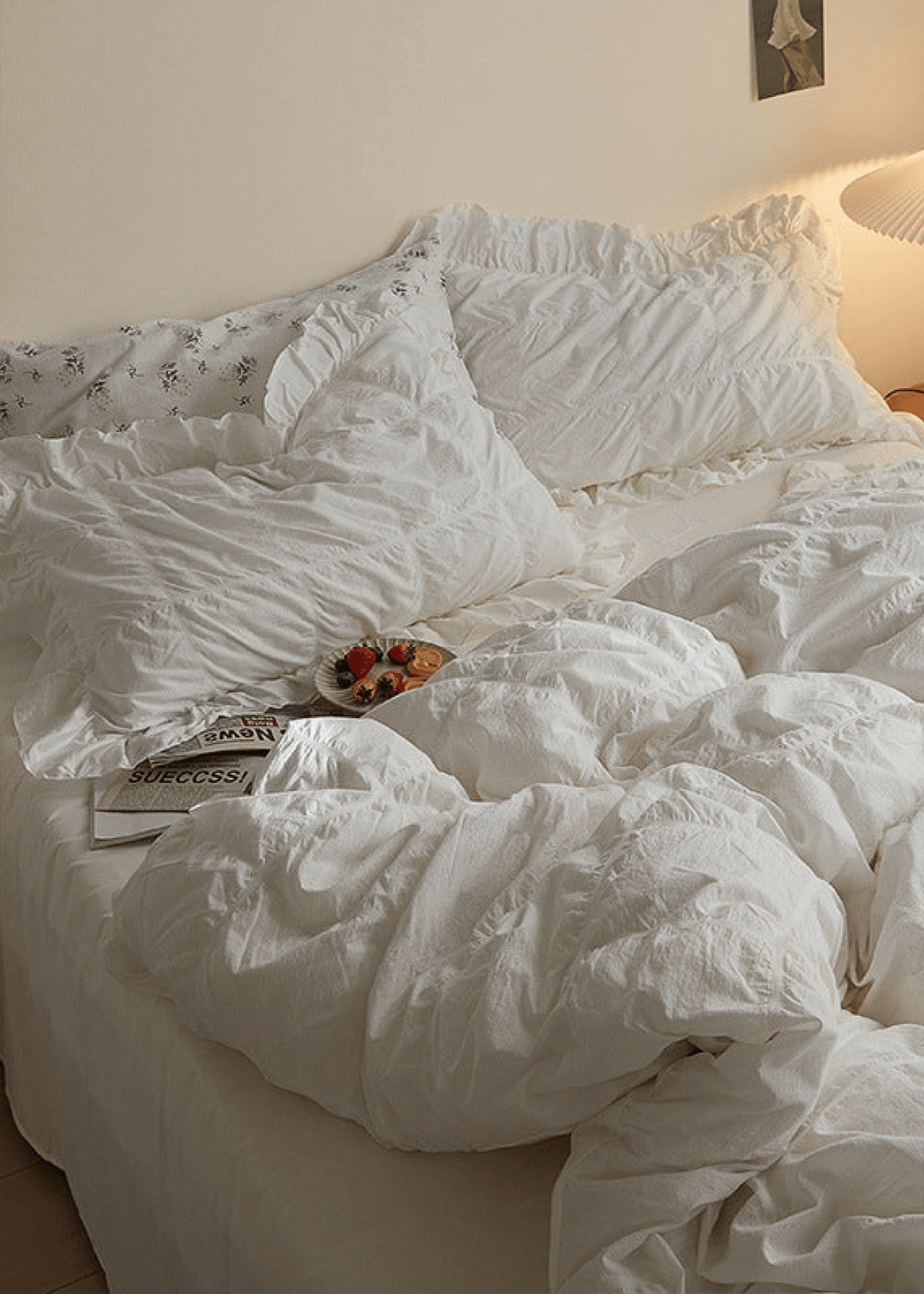 Odessa Ruffled Cotton Blend Bedding Set – ivory ruffled pillows and duvet beside a warm bedside lamp - Roomden