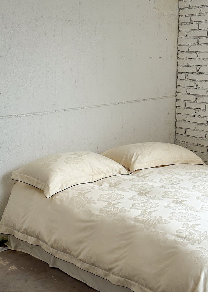 Ondine Floral Cotton Blend Bedding Set – ivory floral duvet and matching pillows viewed from the side - Roomden