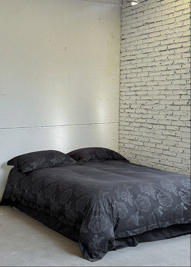 Ondine Floral Cotton Blend Bedding Set – full black floral bed against a white brick wall - Roomden
