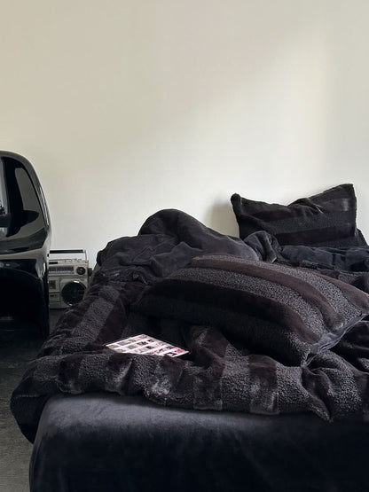 Black wide striped plush fleece bedding set styled in a minimalist room with modern decor and cozy texture - RoomDen