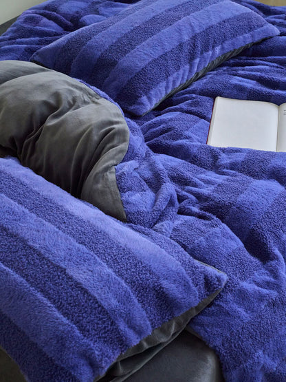 Close-up of blue plush fleece bedding showing fluffy thick texture and soft cozy stripes - RoomDen